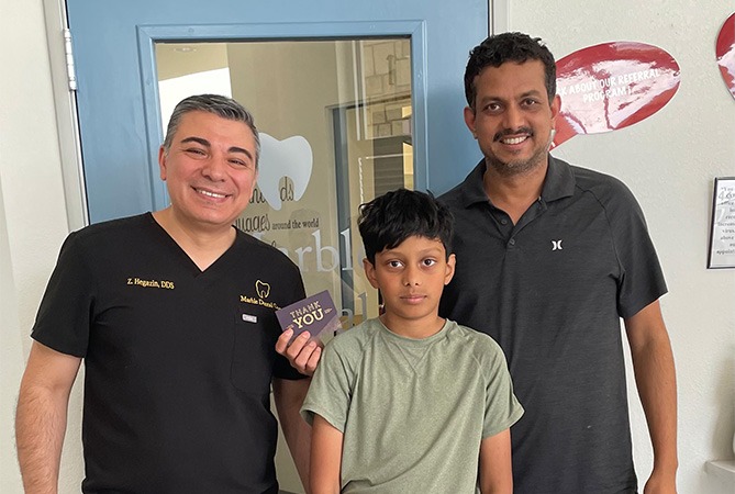 Smiling dentist and two patients outside of Marble Dental McKinney