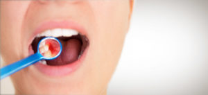 woman with gum disease brushing her teeth