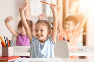 child in class raising their hands