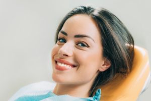 Woman smiling in chair during visit with dentist in McKinney