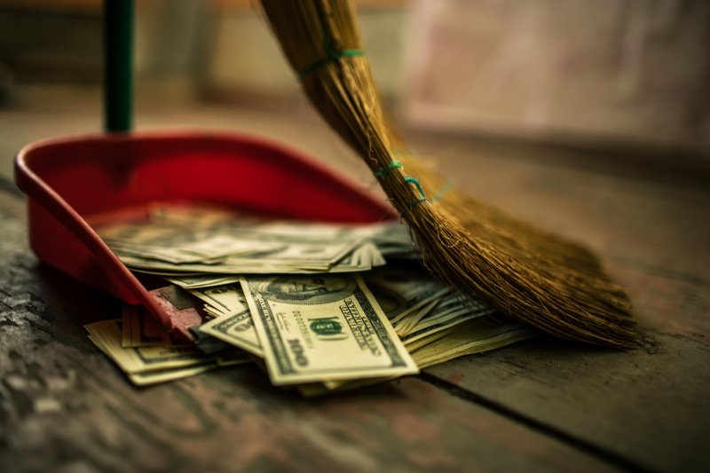 Money being swept into dustpan