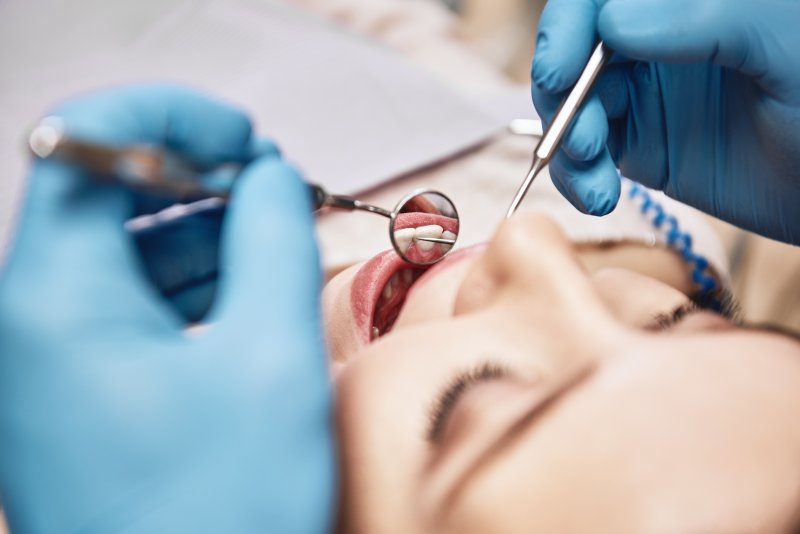 dentist inspecting mouth during routine checkup