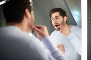 Man looking in the mirror for gum bumps