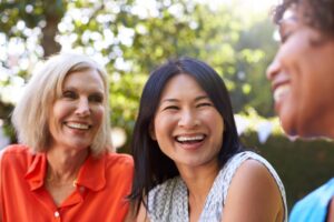 group of smiling middle-aged women talking outside