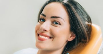 Woman smiling in chair during visit with dentist in McKinney