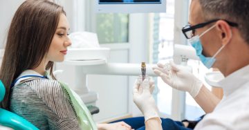 Dentist showing a dental implant to a patient