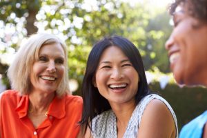 Predicting Success: How Dental Implants Make It Happen 1 group of smiling middle-aged women talking outside