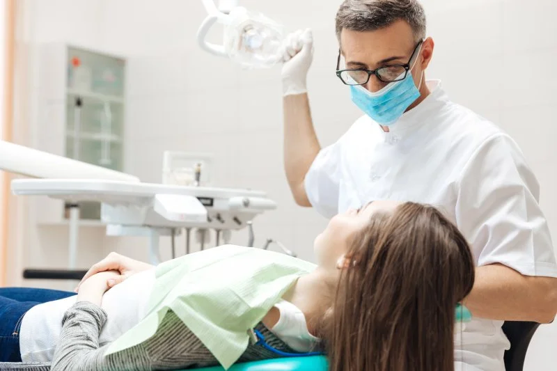 a dentist examining a female patient